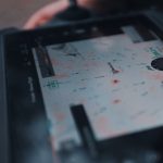 Angled view of tablet screen showing drone information and topographical map